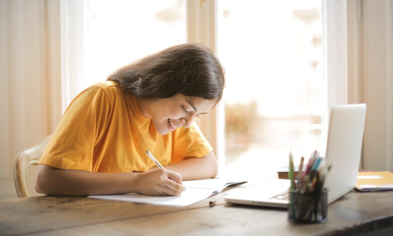 Woman in Yellow Shirt Writing on White Paper